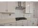 Close up of kitchen showing gas stovetop with white quartz countertop and cabinetry at 5350 Woodline View Cir, Hoschton, GA 30548