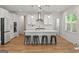 Bright kitchen boasts white cabinets, stainless steel appliances, a large island with barstool seating at 5350 Woodline View Cir, Hoschton, GA 30548