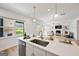 Open concept kitchen island with modern appliances and views of the living room at 5350 Woodline View Cir, Hoschton, GA 30548