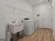 Functional laundry room featuring a utility sink, washer and dryer, and overhead storage at 5350 Woodline View Cir, Hoschton, GA 30548