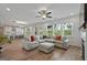 Spacious open-concept living room with hardwood floors, large windows and flows seamlessly into the kitchen at 5350 Woodline View Cir, Hoschton, GA 30548