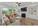 Bright living room with a cozy fireplace, built-in shelving, and large windows at 5350 Woodline View Cir, Hoschton, GA 30548
