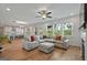 Spacious living room with hardwood floors open to kitchen featuring bright windows for natural light at 5350 Woodline View Cir, Hoschton, GA 30548