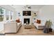 Bright and airy living room featuring built-in shelves, fireplace, and hardwood floors at 5350 Woodline View Cir, Hoschton, GA 30548