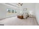Bright main bedroom with a tray ceiling, large windows, and comfortable king-size bed at 5350 Woodline View Cir, Hoschton, GA 30548