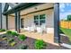 Inviting front porch featuring rocking chairs and meticulous landscaping at 5350 Woodline View Cir, Hoschton, GA 30548