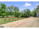 Spacious backyard featuring a wooden deck with wrought iron railing overlooking lush greenery and mature trees at 719 Bethpage Dr, Mcdonough, GA 30253