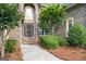 Close-up of the front entrance featuring stone archway, elegant door and manicured shrubbery at 719 Bethpage Dr, Mcdonough, GA 30253