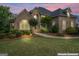 Stunning brick home at dusk with manicured lawn and professional landscaping, enhanced virtually at 719 Bethpage Dr, Mcdonough, GA 30253