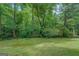 Lush green backyard and a peaceful wooded backdrop offers privacy and a serene atmosphere at 1201 Justin Ln, Lithonia, GA 30058