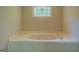 Close up view of a bathtub with stained glass window at 1201 Justin Ln, Lithonia, GA 30058
