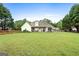 Expansive backyard featuring a well-maintained lawn, a charming picket fence, and a covered porch at 235 Surrey Park Dr, Fayetteville, GA 30215