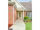 Inviting entryway featuring a decorative glass door, brick facade, and beautifully landscaped garden beds at 235 Surrey Park Dr, Fayetteville, GA 30215