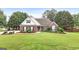 Beautiful single-story brick home with well-manicured lawn and mature trees offering great curb appeal at 235 Surrey Park Dr, Fayetteville, GA 30215