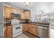 Well-lit kitchen with wood cabinets, black countertops, and seamless flow to the dining area at 235 Surrey Park Dr, Fayetteville, GA 30215