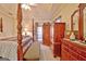 Elegant primary bedroom with a four-poster bed, well-lit vanity, and a view of the outdoors at 170 Habersham Dr, Fayetteville, GA 30214