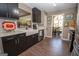 Well-lit kitchen with black cabinetry, stainless steel appliances, and wood-look flooring leading to dining area at 11 Line Creek Cir, Sharpsburg, GA 30277