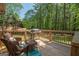 Relaxing outdoor deck with seating, a grill, and a scenic view of lush greenery at 11 Line Creek Cir, Sharpsburg, GA 30277