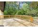 This is a spacious wooden back deck surrounded by green trees at 2687 Fairfield Sw Dr, Marietta, GA 30064