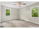 Bright bedroom with wood-look flooring, a ceiling fan, and two windows providing ample natural light at 2687 Fairfield Sw Dr, Marietta, GA 30064