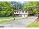View of the home's front exterior with a two-car garage and gravel driveway entrance at 2687 Fairfield Sw Dr, Marietta, GA 30064