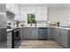 Updated kitchen showcasing sleek gray cabinets, quartz countertops, white subway tile, and stainless steel appliances at 2687 Fairfield Sw Dr, Marietta, GA 30064