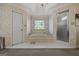 A primary bathroom suite with a soaking tub and a separate shower, complete with carpet flooring and floral wallpaper at 2810 Jodeco Ter, Jonesboro, GA 30236
