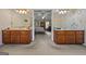 Primary bathroom featuring double sinks with decorative mirrors, tile flooring, and seamless access to the primary bedroom at 2810 Jodeco Ter, Jonesboro, GA 30236