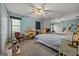 Cozy carpeted bedroom with blue walls, a ceiling fan, multiple mirrors, and a vanity for getting ready in the morning at 2810 Jodeco Ter, Jonesboro, GA 30236