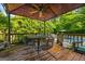 Covered deck features metal table, chairs, and ceiling fan overlooking backyard and lush trees at 2810 Jodeco Ter, Jonesboro, GA 30236