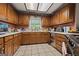 Classic kitchen showcases abundant wood cabinetry, tile flooring, window above the sink, and stainless steel dishwasher at 2810 Jodeco Ter, Jonesboro, GA 30236