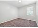 Cozy bedroom with neutral walls, plush carpet, and a window bringing in natural light at 11203 Hemlock Rd, Hampton, GA 30228