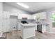 Bright kitchen with white cabinets, marble countertops, stainless steel appliances, and an island at 11203 Hemlock Rd, Hampton, GA 30228