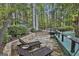 Backyard with stone patio, lounge chairs, a green shed, and surrounded by trees creating a peaceful outdoor area at 120 Tall Pine Dr, Fayetteville, GA 30214