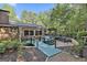 Spacious backyard deck with a bridge, stone patio, lounge chairs, and an outdoor dining area at 120 Tall Pine Dr, Fayetteville, GA 30214