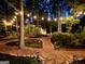 Backyard with string lights, landscape lighting, mulch beds, and a path leading to a small outdoor shed at 120 Tall Pine Dr, Fayetteville, GA 30214