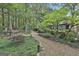 Landscaped backyard featuring a pea gravel path leading to the home and a green shed with lots of surrounding trees at 120 Tall Pine Dr, Fayetteville, GA 30214