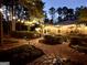 Dusk view of backyard landscaped with ambient outdoor lighting and elegant walking paths at 120 Tall Pine Dr, Fayetteville, GA 30214
