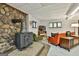 Finished basement with stone accent wall, a wood-burning stove, and vintage mid-century modern furniture at 120 Tall Pine Dr, Fayetteville, GA 30214