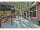Expansive green deck with a pergola, featuring outdoor seating, a brick exterior and surrounded by mature trees at 120 Tall Pine Dr, Fayetteville, GA 30214