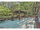 Large green deck with pergola featuring string lights providing an inviting outdoor space for entertaining and relaxing at 120 Tall Pine Dr, Fayetteville, GA 30214