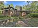 Back exterior of a brick house featuring large trees and a screened-in porch, perfect for enjoying the outdoors at 120 Tall Pine Dr, Fayetteville, GA 30214