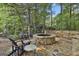 Cozy stone fire pit surrounded by comfortable seating and lush landscaping creates a perfect outdoor gathering space at 120 Tall Pine Dr, Fayetteville, GA 30214