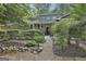 Classic brick home with lush landscaping features a mulched front yard and stone walkway to front door at 120 Tall Pine Dr, Fayetteville, GA 30214