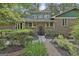 Inviting brick home with a black front door, large windows, and mature landscaping at 120 Tall Pine Dr, Fayetteville, GA 30214