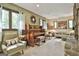 Sunlit living room with classic piano, plush seating and decorative fireplace at 120 Tall Pine Dr, Fayetteville, GA 30214