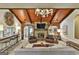 Spacious living room features a stone fireplace, wood ceiling, and stylish mid-century modern design at 120 Tall Pine Dr, Fayetteville, GA 30214