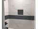 Clean bathroom featuring white marble-look tiling, contrasting accent tile and a built-in shower niche at 3189 Jackson, Hapeville, GA 30354