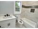 Bright bathroom with a white vanity, toilet, and tub with tile surround and a window view at 3189 Jackson, Hapeville, GA 30354