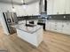 This kitchen includes stainless steel appliances, granite countertops, island with sink, and white cabinets at 3189 Jackson, Hapeville, GA 30354